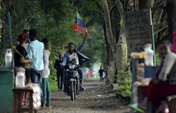 A man rides a motorcycle as young people of the Sidama ethnic group, the largest in southern Ethiopia, celebrate at Hawassa city over plans by local elders to declare the establishment of a breakaway region for the Sidama, in Awasa, July 15, 2019. Authorities arrested three media workers from the Sidama Media Network on July 18. (AFP/Michael Tewelde)