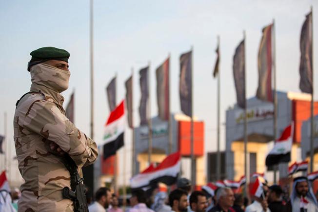 A member of the Iraqi security forces stands guard outside the Basra local government headquarters on July 19, 2019, as protesters gather for a demonstration. Basra police attempted to arrest Iraqi reporter Hassan Sabah in a raid on his home in Basra on July 23. (AFP/Hussein Faheh)