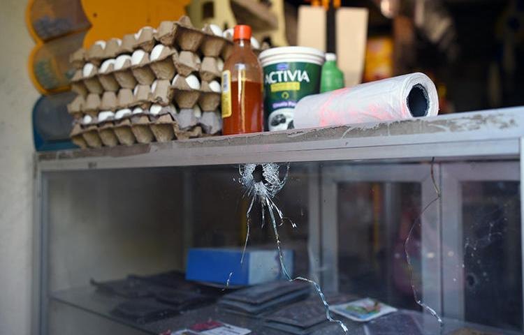 A bullet hole is seen at a grocery store belonging to Jorge Celestino Ruiz Vázquez, who was shot dead in Veracruz state on August 2. Ruiz, a reporter for El Gráfico, is the third journalist killed in one week in Mexico. (AFP/Victoria Razo)
