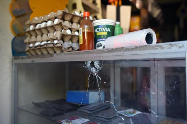A bullet hole is seen at a grocery store belonging to Jorge Celestino Ruiz Vázquez, who was shot dead in Veracruz state on August 2. Ruiz, a reporter for El Gráfico, is the third journalist killed in one week in Mexico. (AFP/Victoria Razo)