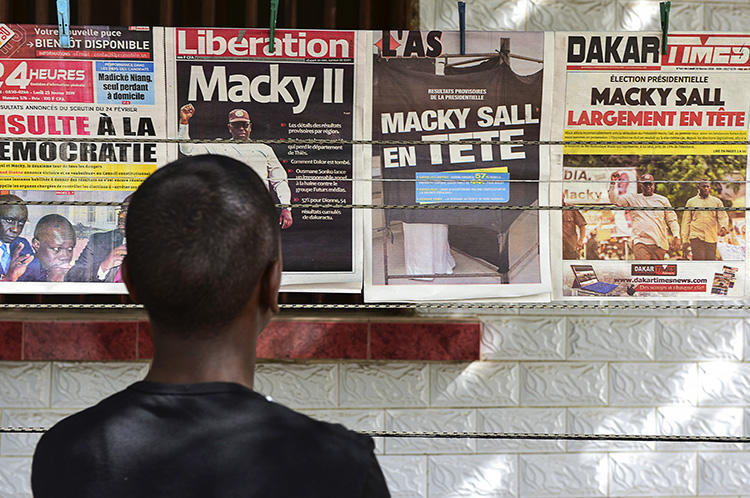 A man looks at newspaper front pages in Dakar, on February 25, 2019, one day after Senegal's presidential elections. Senegalese authorities arrested critical journalist Adama Gaye on July 29. (AFP/Seyllou)
