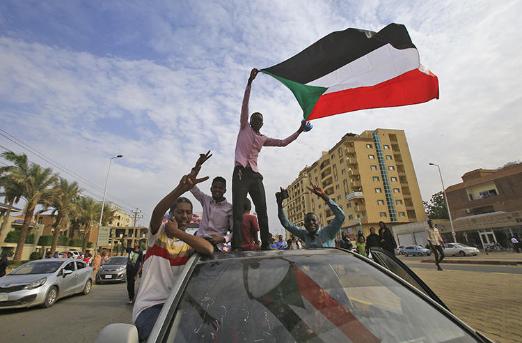 Sudanese protesters wave the national flag during a demonstration in the capital Khartoum on August 1, 2019. On July 24, authorities detained Al-Sayha newspaper editor-in-chief and journalists’ union head Sadiq al-Rizaigi. (AFP/Ashraf Shazly)