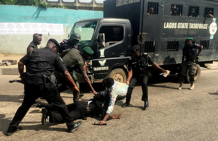 Police officers pull a journalist during an anti-government protest in Lagos, Nigeria, on August 5, 2019. At least four journalists were detained during the protests. (Reuters/Nneka Chile)