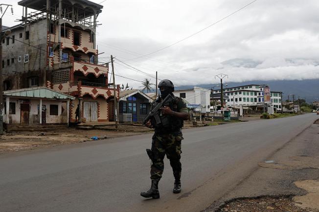 A Cameroonian elite Rapid Intervention Battalion member walks along an empty street in the city of Buea in Cameroon's Anglophone southwest region on October 4, 2018. Cameroon’s military detained pidgin news anchor Samuel Wazizi on August 2, 2019, in Buea. (Reuters/Zohra Bensemra)