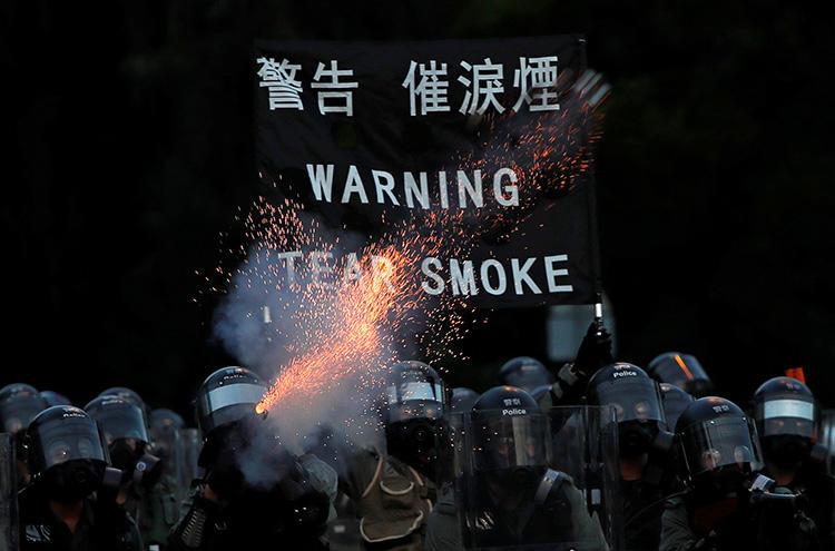 Police fire tear gas during protests in Hong Kong on August 5. A video journalist was knocked unconscious after being hit in the head by a tear gas canister while covering unrest in the Sham Shui Po district. (Reuters/Tyrone Siud)
