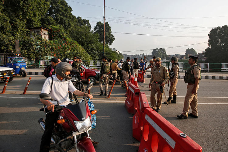 Indian security personnel stop people during restrictions in Srinagar, in Indian-controlled Jammu and Kashmir state, on August 5, 2019. Indian authorities that day blocked the internet and communications networks in the region. (Reuters/Danish Ismail)