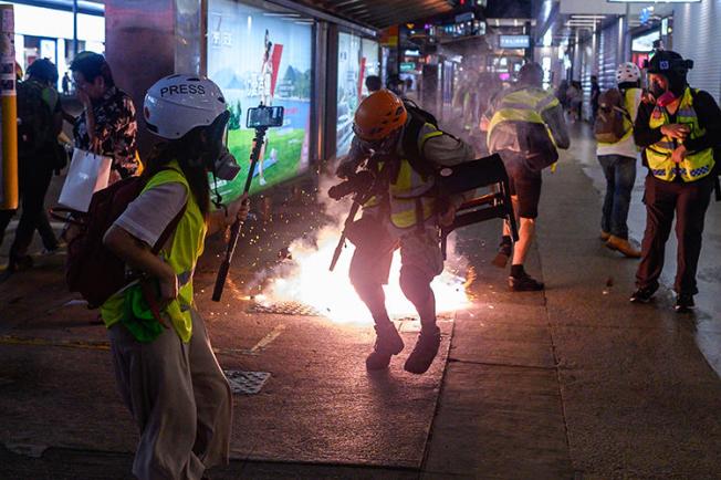 Journalists react as police fire tear gas in Hong Kong on September 8, 2019. Police recently fired tear gas and pepper spray at several groups of journalists covering protests in the city. (AFP/Philip Fong)