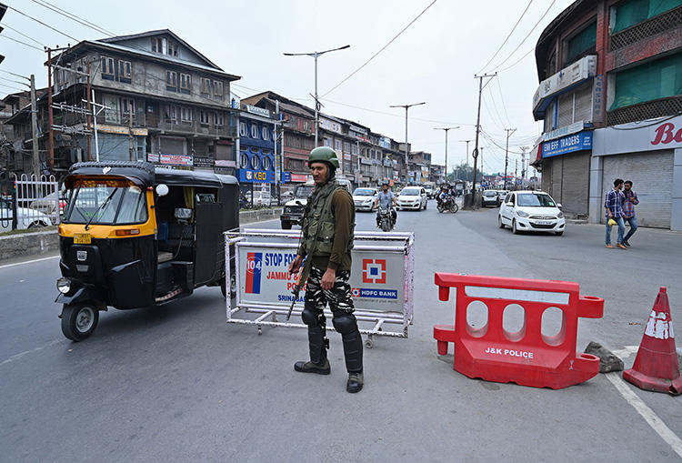 An Indian paramilitary trooper stands guard on a road in Srinagar, Kashmir's largest city, on September 7, 2019. Since the government stripped the region of its limited autonomous status and imposed a communication blackout in early August, Kashmir’s news media has faced a deep existential crisis. (AFP/Tauseef Mustafa)