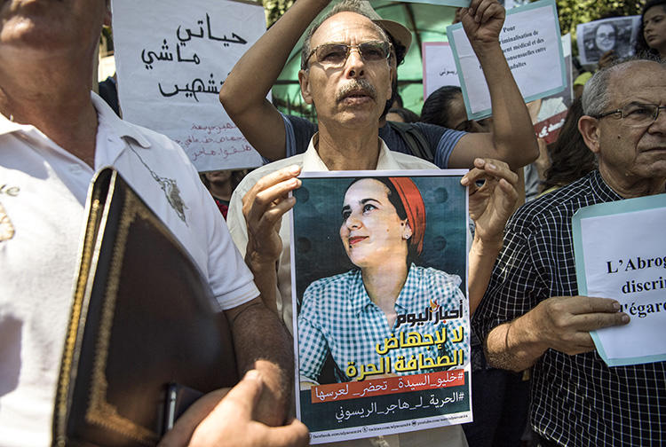 A demonstrator holds up a sign showing the portrait of Hajar Raissouni, a Morrocan journalist of the daily newspaper Akhbar El-Youm, during a protest outside a courthouse in the capital, Rabat, on September 9, 2019. (AFP/Fadel Senna)