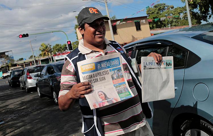 A newspaper vendor sells "La Prensa" and "El Nuevo Diario" on January 18, 2019. Customs authorities have withheld ink and newsprint supplies from both papers since August 2018. (AFP/Inti Ocon)