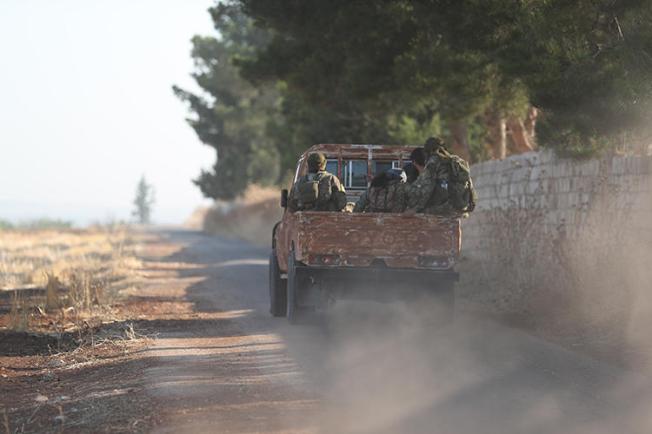 Fighters from Hayat Tahrir al-Sham are seen on the border between Hama and Idlib provinces, in Syria, on July 11, 2019. Militants from the group recently abducted journalist Ahmed Rahal in Idlib. (AFP/Omar Haj Kadour)