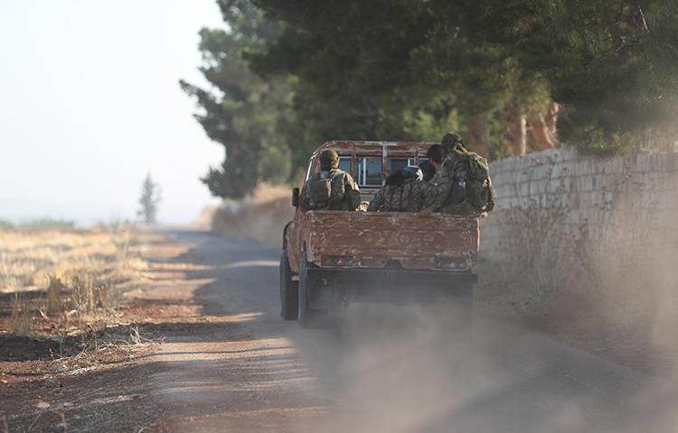 Fighters from Hayat Tahrir al-Sham are seen on the border between Hama and Idlib provinces, in Syria, on July 11, 2019. Militants from the group recently abducted journalist Ahmed Rahal in Idlib. (AFP/Omar Haj Kadour)