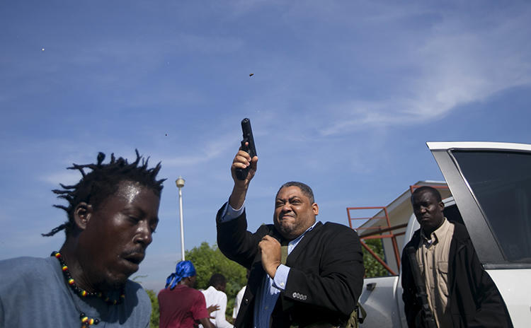 Le Sénateur Jean Marie Ralph Féthière fait feu avec son arme à Port-au-Prince, Haïti, le 23 septembre 2019. Le photographe de l’AP Chery Dieu-Nalio a été blessé par le tir au cours de l’incident. (AP/Chery Dieu-Nalio)