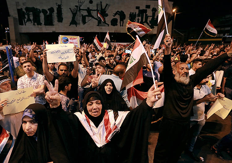 Iraqi protesters chant slogans during a demonstration in Tahrir Square in central Baghdad, Iraq, on June 21, 2019. Iraq suspended U.S.-funded broadcaster Al-Hurrah for 3 months over a corruption report on September 2. (AP Photo/Hadi Mizban)