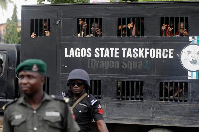 Police officers are seen in Lagos, Nigeria, on August 5, 2019. Lagos police recently arrested publisher Agba Jalingo, who has been charged by federal authorities with treason. (AP/Sunday Alamba)