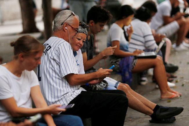Personas usan internet en un hot-spot en La Habana, Cuba, en diciembre de 2018. Periodistas y blogeros dicen que recientes regulaciones de internet podrían legitimar la censura. (REUTERS/Stringer)