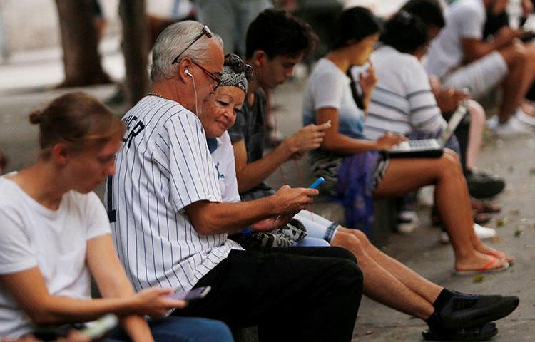 Personas usan internet en un hot-spot en La Habana, Cuba, en diciembre de 2018. Periodistas y blogeros dicen que recientes regulaciones de internet podrían legitimar la censura. (REUTERS/Stringer)