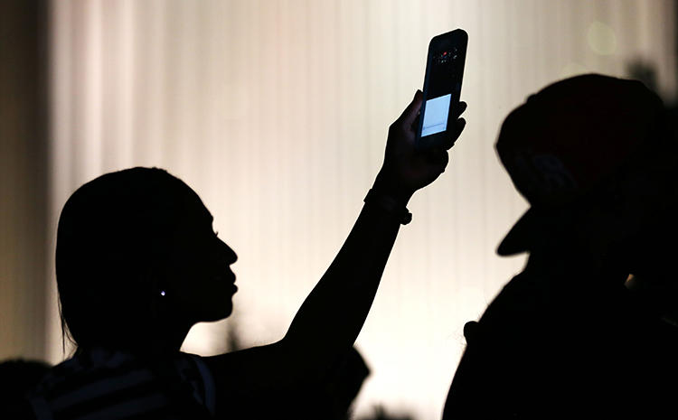 Una manifestante utiliza su teléfono para filmar durante una protesta en Charlotte, Carolina del Norte, en septiembre de 2016. La encuesta sobre seguridad del CPJ halló que el 85 % de las periodistas encuestadas creen que el periodismo se está convirtiendo en una profesión cada vez menos segura. (Reuters/Mike Blake)