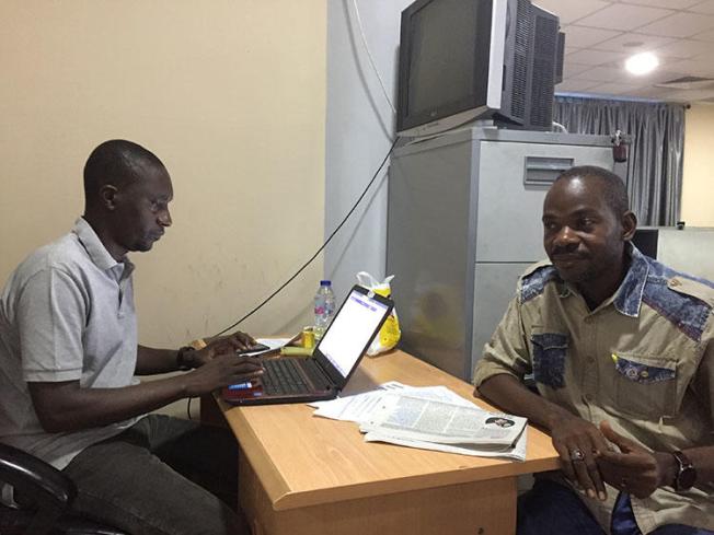 Hamza Idris (à gauche), rédacteur en chef du journal Daily Trust, est assis en février 2019 avec son collègue Hussaini Garba Mohammed dans leur bureau à Abuja, la capitale nigériane. Le bureau a été perquisitionné en janvier par l'armée, qui a saisi 24 ordinateurs. (CPJ / Jonathan Rozen)