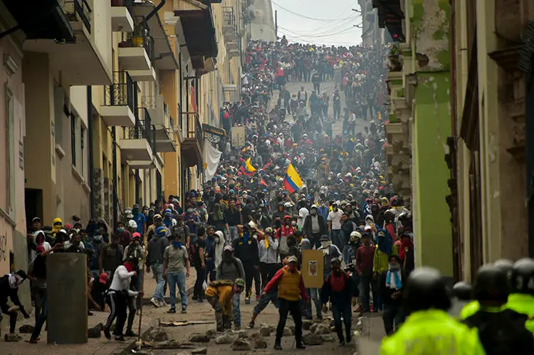 Manifestantes se enfrentan con la policía antidisturbios en Quito, mientras miles marchan contra la decisión del presidente ecuatoriano, Lenín Moreno, de recortar los subsidios al combustible, el 9 de octubre de 2019. Tanto las autoridades como los manifestantes han atacado a la prensa en medio de las protestas. (AFP/Rodrigo Buendia)