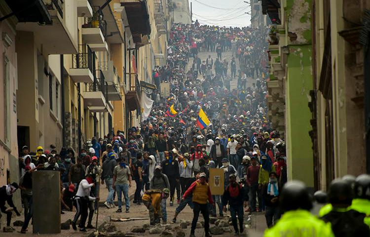 Demonstrators clash with riot police in Quito, as thousands march against Ecuadoran President Lenin Moreno's decision to slash fuel subsidies, on October 9, 2019. Both the authorities and protesters have targeted the press amid the protests. (AFP/Rodrigo Buendia)