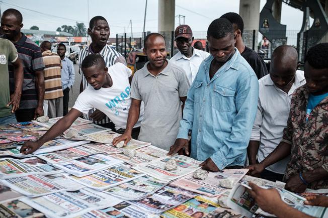 People look at front pages at a newspaper stand in Port Harcourt, after Nigeria's presidential election results were announced on February 27, 2019. Nigerian police beat two Inspiration FM journalists after covering a protest in Uyo, in Akwa-Ibom State, on September 24, 2019. (AFP/Yasuyoshi Chiba)