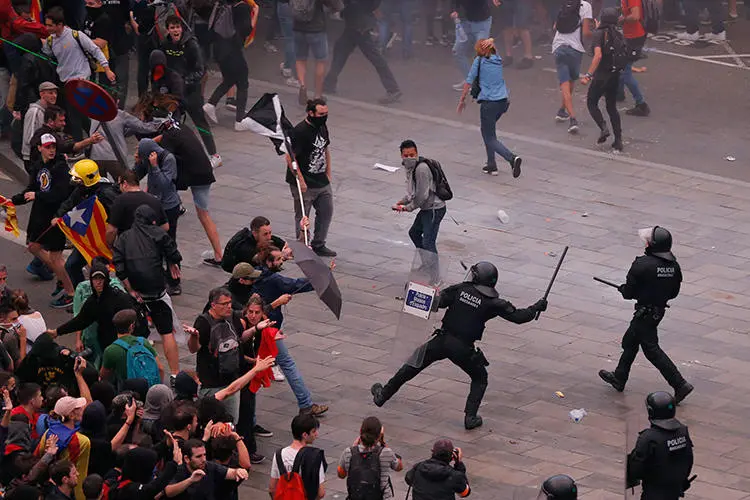 Protesters clash with Spanish policemen outside El Prat airport in Barcelona on October 14, 2019, as thousands of angry protesters took to the streets after Spain's Supreme Court sentenced nine Catalan separatist leaders to jail for sedition over the failed 2017 independence bid. Scores of journalists were injured covering the protests, which continued through October 20. (AFP/Pau Barrena)