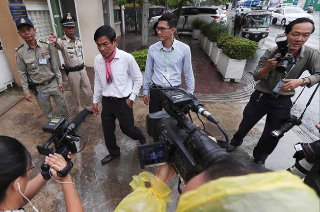Journalists Uon Chhin, center left, and Yeang Sothearin, center right, are seen at the municipal court in Phnom Penh, Cambodia, on August 30, 2019. A municipal court judge recently ordered their case to be reinvestigated. (AP/Heng Sinith)