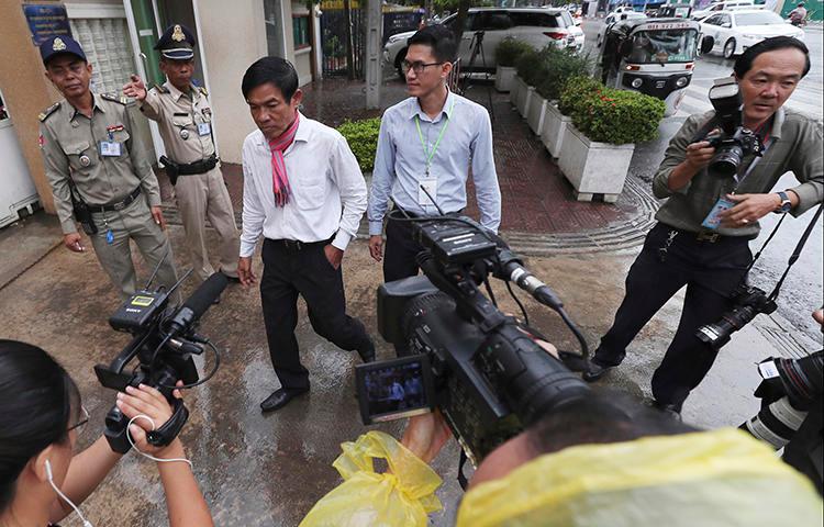 Journalists Uon Chhin, center left, and Yeang Sothearin, center right, are seen at the municipal court in Phnom Penh, Cambodia, on August 30, 2019. A municipal court judge recently ordered their case to be reinvestigated. (AP/Heng Sinith)