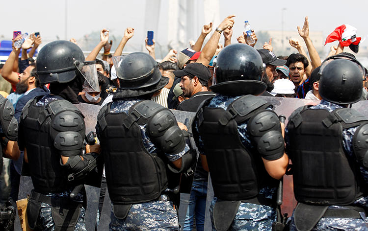 Security forces and protesters are seen in Baghdad, Iraq, on October 2, 2019. Security forces have harassed reporters covering the protests, and authorities recently cut internet access to much of the country. (Reuters/Khalid al-Mousily)