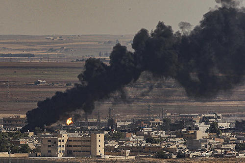 Smoke is seen billowing from the sites of airstrikes in Ras al-Ayn, Syria, on October 13, 2019. Two Syrian Kurdish journalists were killed in the attacks. (AP/Emrah Gurel)