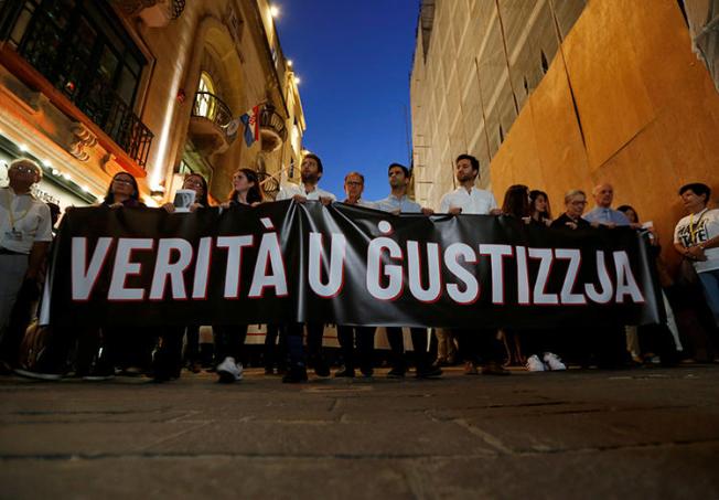 Friends and family members of journalist Daphne Caruana Galizia carry a banner calling for "Truth and Justice" in the investigation into her murder, in Valletta, Malta, on October 16, 2019. Her family and the Maltese government recently reached an agreement on the nature of the investigation. (Reuters/Darrin Zammit Lupi)