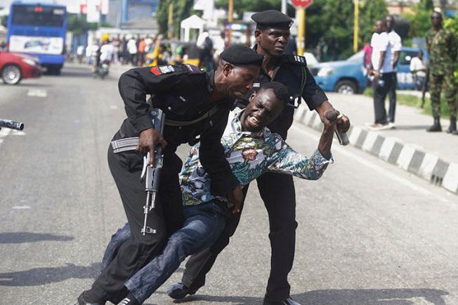 Police officers detain Sahara Reporters journalist Victor Ogungbenro during a protest in Lagos, Nigeria, on August 5, 2019. Staff at the online newspaper report sustained harassment targeting them and their website. (AP/Sunday Alamba)