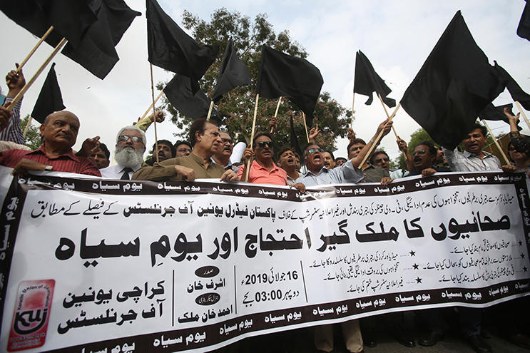 Pakistani journalists protest censorship, holding a banner that reads: "nation wide protest of journalists," in Karachi, Pakistan, Tuesday, July 16, 2019. Pakistani journalists hold nationwide protests to denounce rampant censorship by the country's powerful security services, massive layoffs due to budget cuts and months-long delays in payments of their wages. (AP Photo/Fareed Khan)