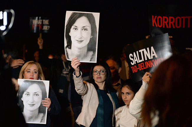 Protesters hold pictures of murdered Maltese journalist Daphne Caruana Galizia as they gather outside the prime minister's office in Valletta, Malta, on November 20, 2019. (AFP/Matthew Mirabelli)