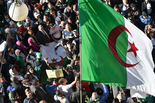 Protesters wave national flags as they gather for a demonstration against the government and the ruling class in Algiers on November 29, 2019. Algerians are due to vote in a presidential election on December 12. (AFP/Ryad Kramdi)