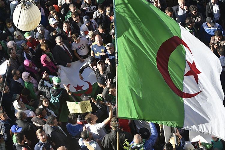 Protesters wave national flags as they gather for a demonstration against the government and the ruling class in Algiers on November 29, 2019. Algerians are due to vote in a presidential election on December 12. (AFP/Ryad Kramdi)