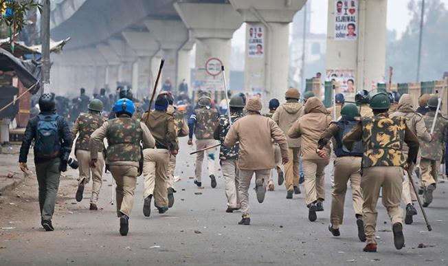 Police officers chase protesters in New Delhi, India, on December 17, 2019. Several journalists have been attacked since the protests began. (AP/Manish Swarup)