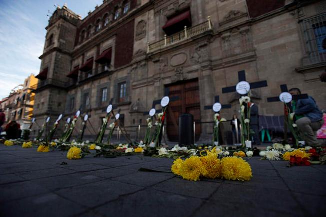 Flowers and crosses bear the names of journalists and human rights defenders murdered in the first three months since President Andrés Manuel López Obrador took office, in Mexico City in February 2019. At least two of the journalists murdered for their work in 2019 were enrolled in a safety protection mechanism. (AP/Rebecca Blackwell)