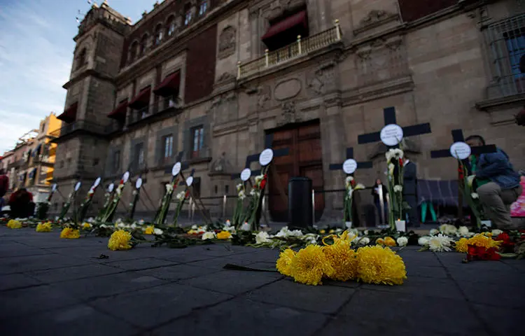 Flowers and crosses bear the names of journalists and human rights defenders murdered in the first three months since President Andrés Manuel López Obrador took office, in Mexico City in February 2019. At least two of the journalists murdered for their work in 2019 were enrolled in a safety protection mechanism. (AP/Rebecca Blackwell)
