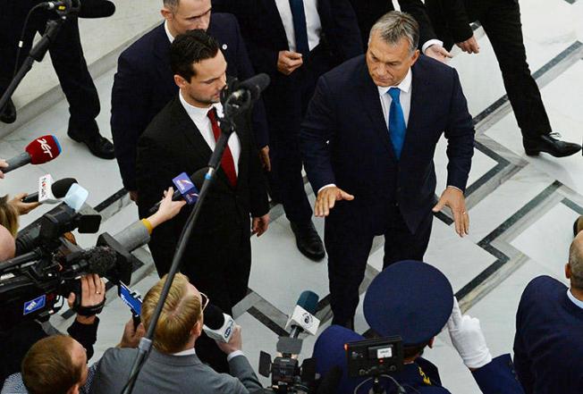 Hungarian Prime Minister Viktor Orbán, right, gestures as he walks past journalists after talks in Warsaw, Poland, in September 2017. A joint mission to Hungary in November 2019 found that the government has pursued a strategy to silence the country's press. (AP/Alik Keplicz)