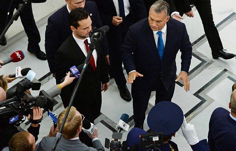 Hungarian Prime Minister Viktor Orbán, right, gestures as he walks past journalists after talks in Warsaw, Poland, in September 2017. A joint mission to Hungary in November 2019 found that the government has pursued a strategy to silence the country's press. (AP/Alik Keplicz)