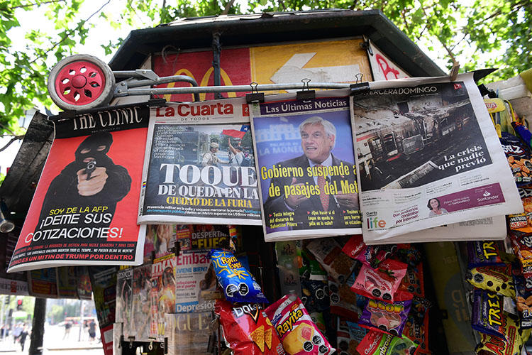 Diarios chilenos son vendidos en Santiago, el 20 de octubre de 2019. Atacantes enmascarados irrumpen en las oficinas del periódico chileno El Mercurio de Antofagasta, dañan equipos y prenden incendios. (AFP/Martin Bernetti)