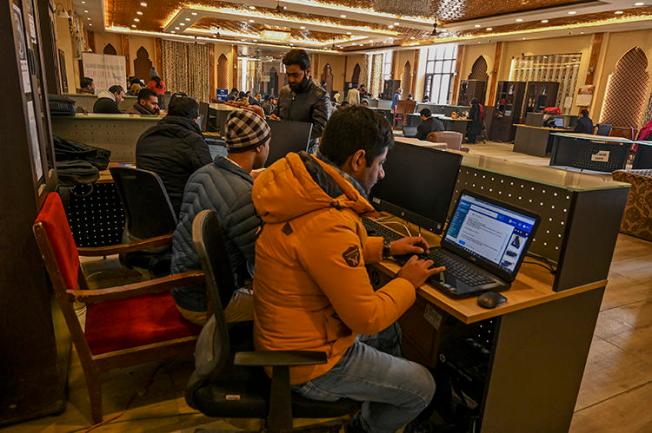Kashmiri students use the internet at a Tourist Reception Centre in Srinagar on December 3, 2019, amid an internet suspension across the region as part of a partial communication blockade by the Indian government. Despite a Supreme Court ruling in January 2020, internet access has only been partially restored, and many news outlets remain offline. (AFP/Tauseef Mustafa)