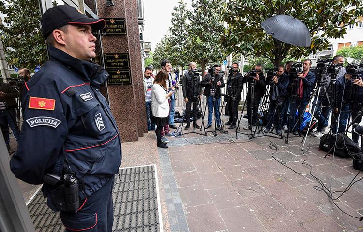 Journalists and law enforcement are seen in Podgorica, Montenegro, on May 9, 2019. Montenegro authorities recently arrested journalist Anđela Đikanović and charged her with incitement. (AFP/Savo Prelevic)