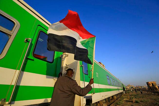 Sudanese protesters wait at a railway station in Khartoum on December 19, 2019 ahead of celebrations of the one-year anniversary of a protest movement that ousted the president. The transitional government in January suspended four news outlets over alleged links to the previous regime. (AFP/Ashraf Shazly)