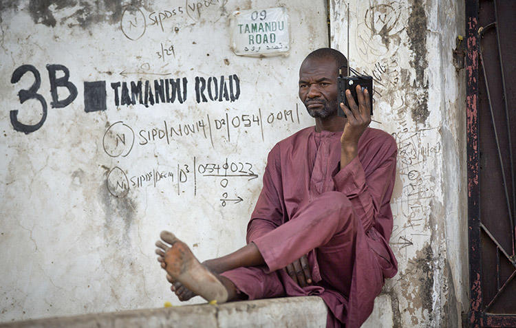 A man listens to a portable radio in Kano, northern Nigeria in 2015. Police in Nigeria's Adamawa State are investigating after a radio journalist was attacked and killed on January 15. (AP/Ben Curtis)