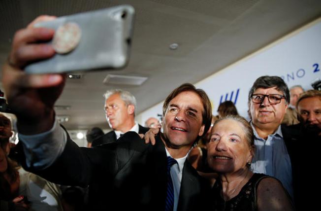 Uruguayan President-elect Luis Lacalle Pou takes a selfie during the announcement of his incoming cabinet, in Montevideo, Uruguay, in December 2019. His party is seeking to introduce the "right to be forgotten" in a hasty legislative process, raising press freedom concerns. (Reuters/Mariana Greif)
