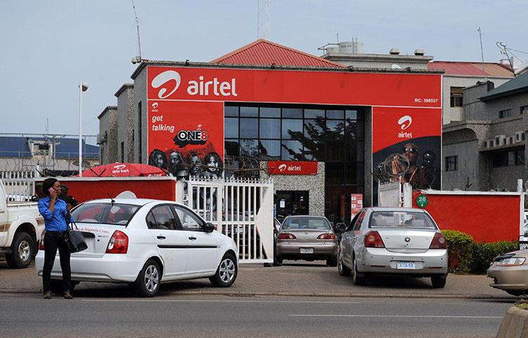 A woman makes a phone call in front of India-owned Airtel on October 10, 2011 in Abuja. A Nigerian NGO on February 25, 2020, sued the Nigerian Communications Commission over warrantless access to ‘call data.’ (AFP/Pius Utomi Ekpei)