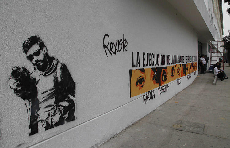 Graffiti shows the likeness of murdered photojournalist Rubén Espinosa and the eyes and names of the other four victims, on the wall of Mexico City attorney general's headquarters in Mexico City, in July 2016. Deadly violence against journalists is rare in the capital, but reporters covering organized crime in the city say threats are on the rise. (AP/Marco Ugarte)